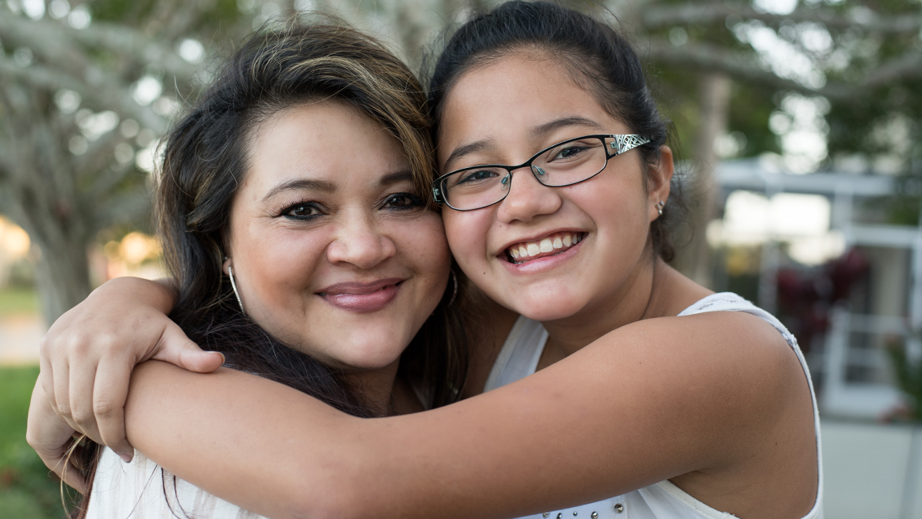 Picture of smiling mother and daughter looking into the camera